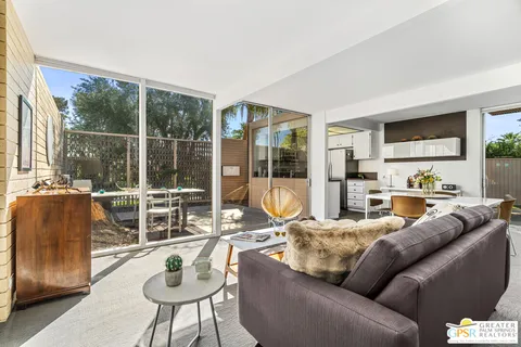a living room with furniture and a floor to ceiling window