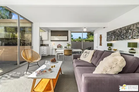 a living room with furniture a flat screen tv and a floor to ceiling window
