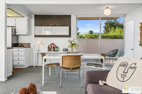 a dining room with furniture and a painting on the wall