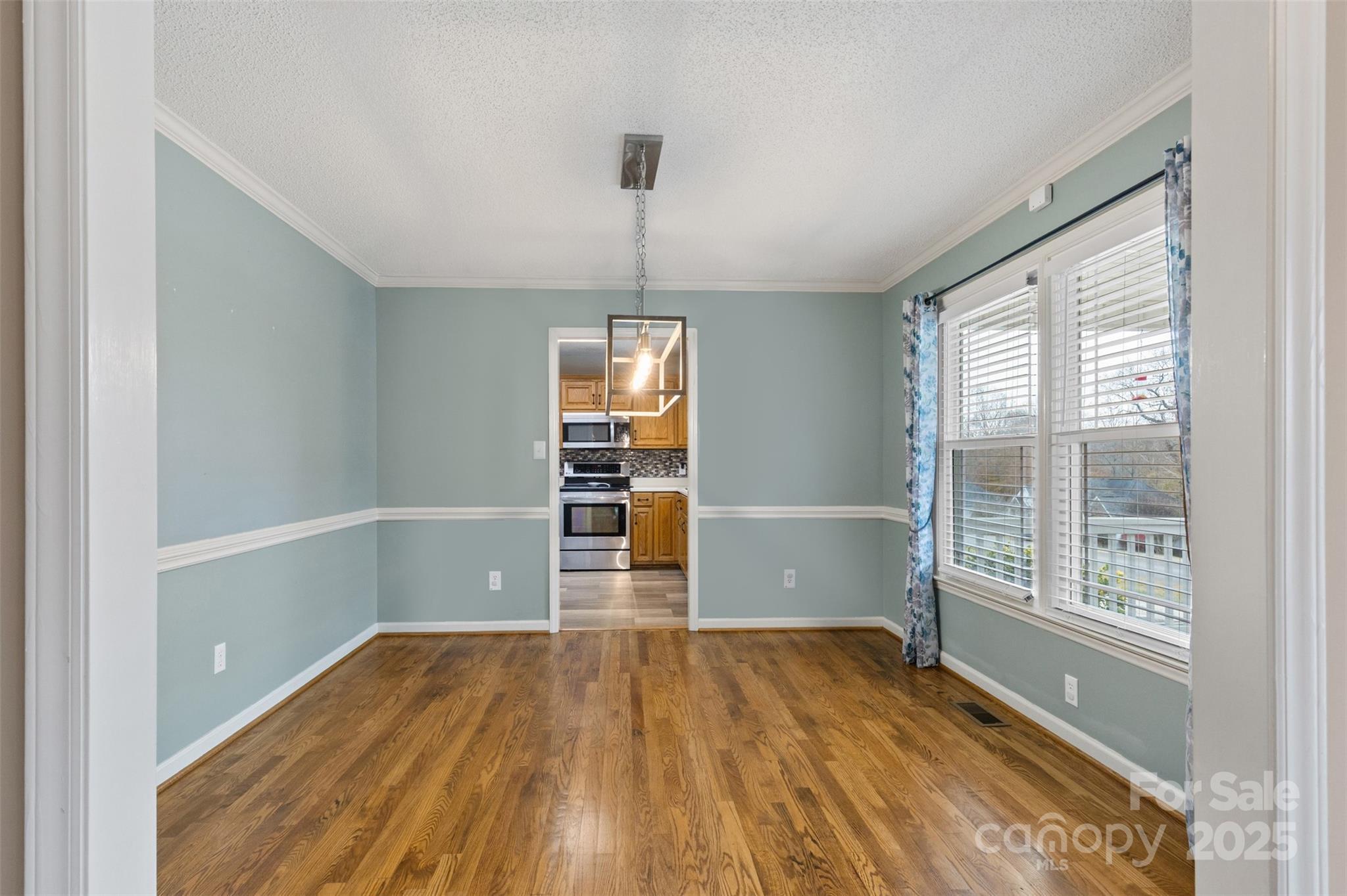 3233 6th Avenue Northeast Conover, NC 28613 - Photo 5 of 30 an empty room with wooden floor cabinet and windows
