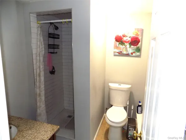 a white toilet sitting next to a bathroom sink and vanity