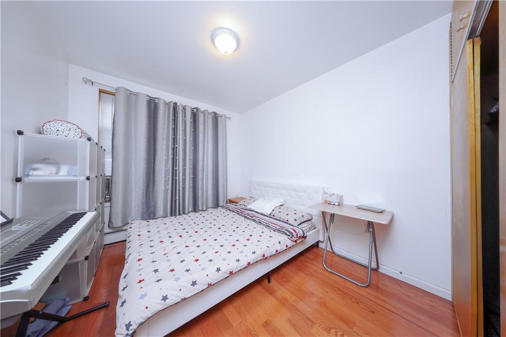 729 59th Street Brooklyn, NY 11220 - Photo 13 of 36 a bedroom with a bed and a dresser