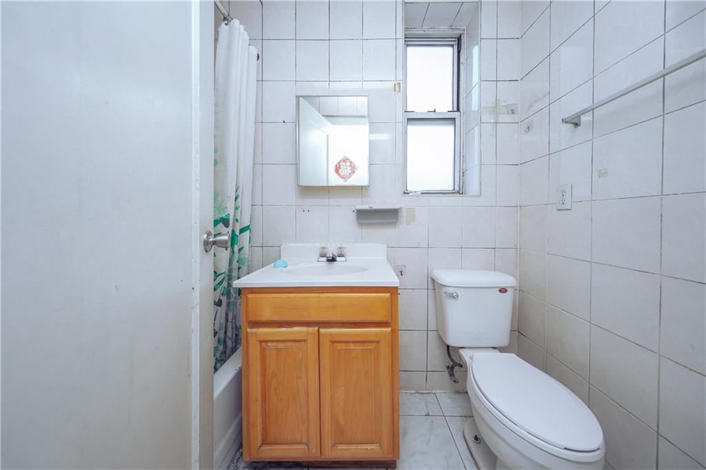 729 59th Street Brooklyn, NY 11220 - Photo 26 of 36 a bathroom with a toilet sink and mirror