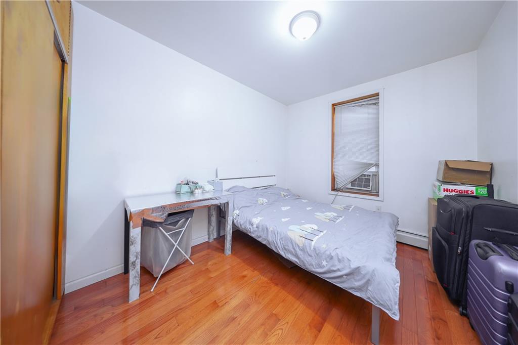 729 59th Street Brooklyn, NY 11220 - Photo 6 of 36 a bedroom with a bed and wooden floor