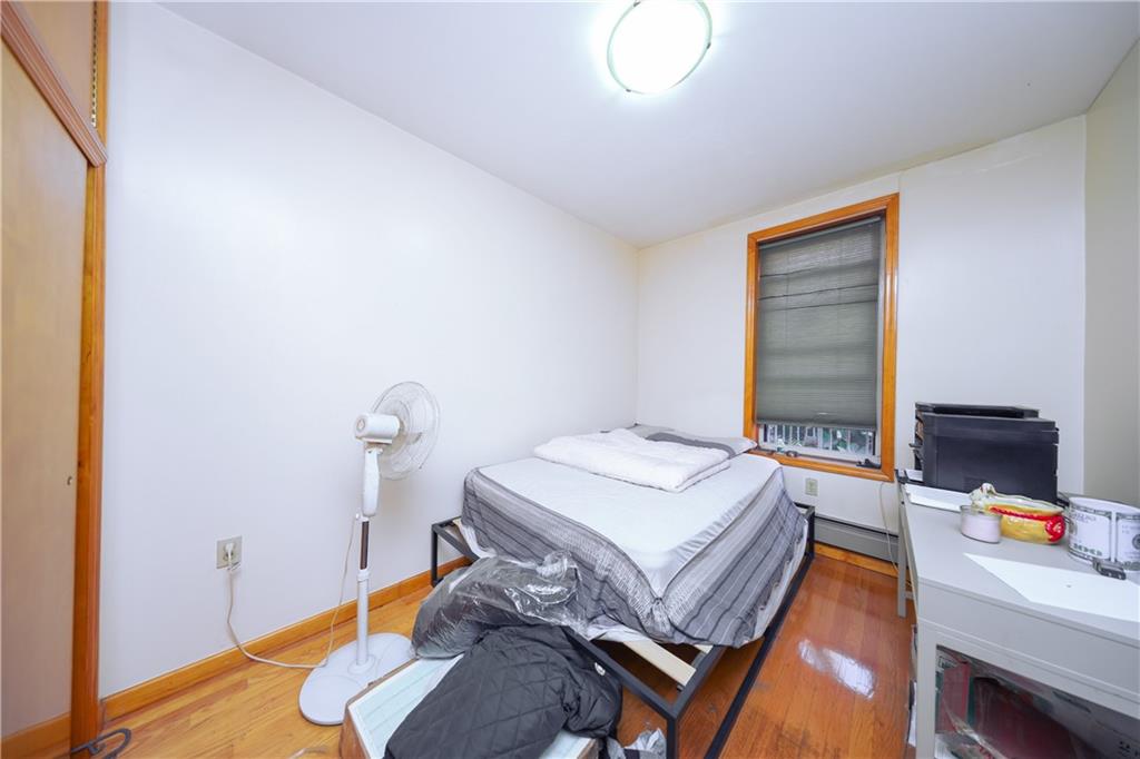 729 59th Street Brooklyn, NY 11220 - Photo 7 of 36 a bedroom with a bed and a table