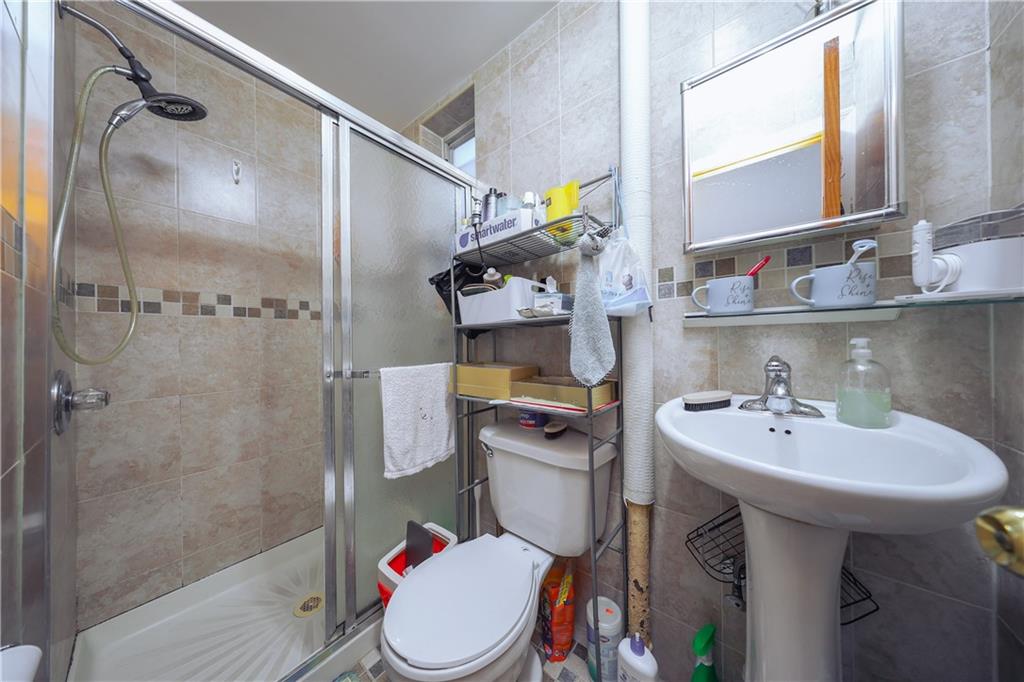 729 59th Street Brooklyn, NY 11220 - Photo 8 of 36 a bathroom with a sink toilet and shower
