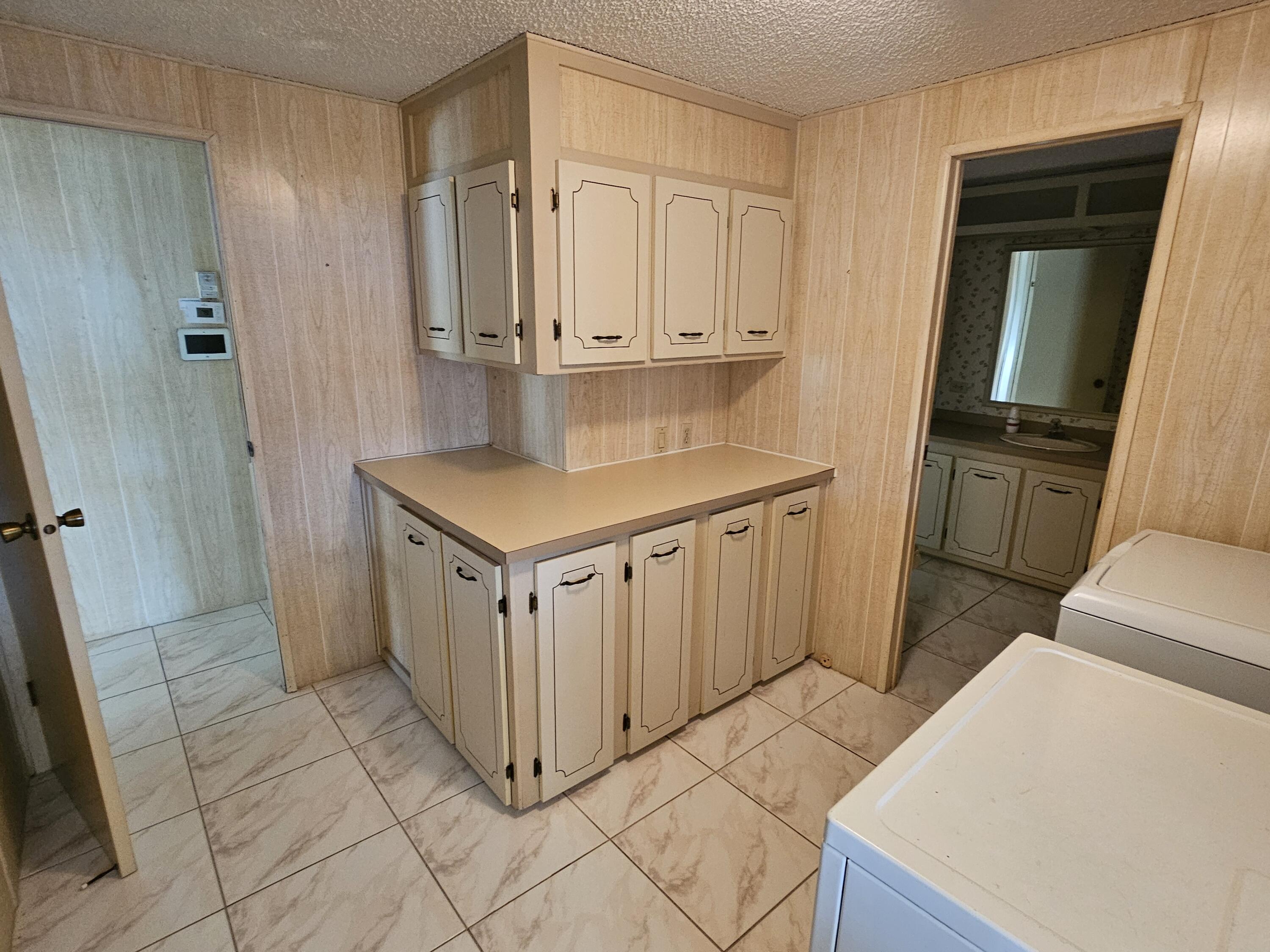 6978 Southeast Delegate Street Hobe Sound, FL 33455 - Photo 15 of 24 a kitchen with white cabinets and refrigerator
