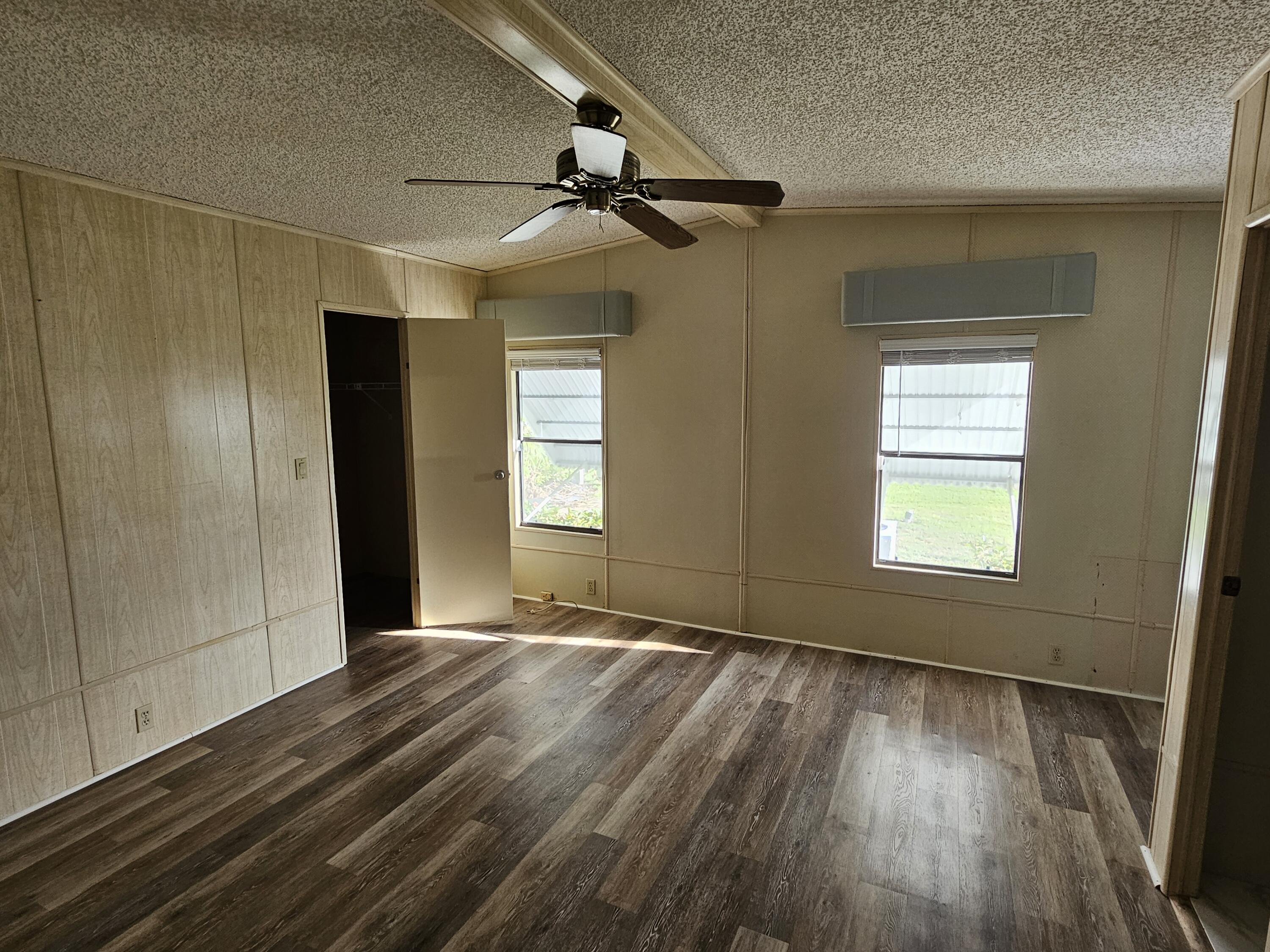 6978 Southeast Delegate Street Hobe Sound, FL 33455 - Photo 18 of 24 a view of an empty room with wooden floor and a window