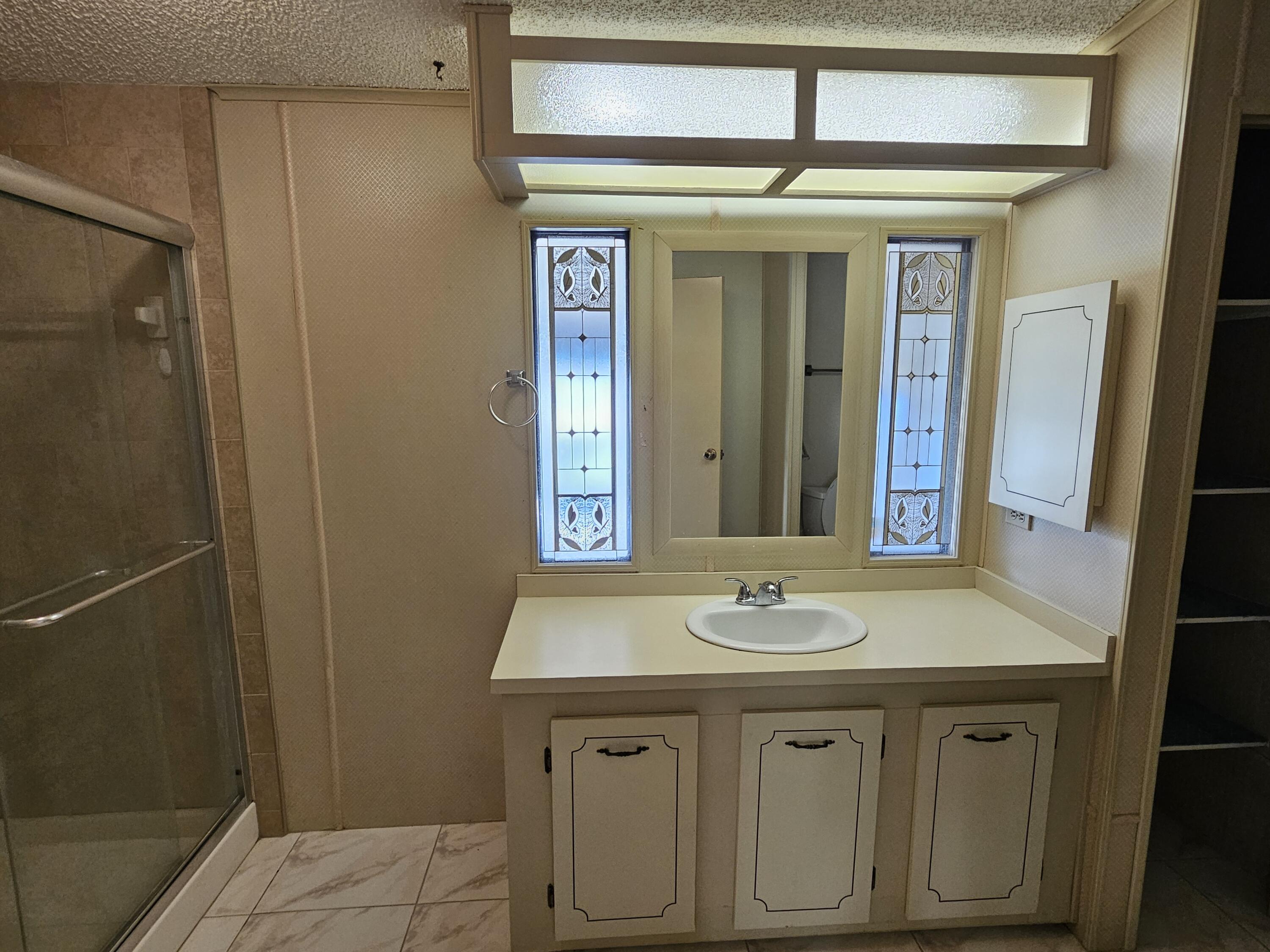 6978 Southeast Delegate Street Hobe Sound, FL 33455 - Photo 19 of 24 a bathroom with a sink and a mirror