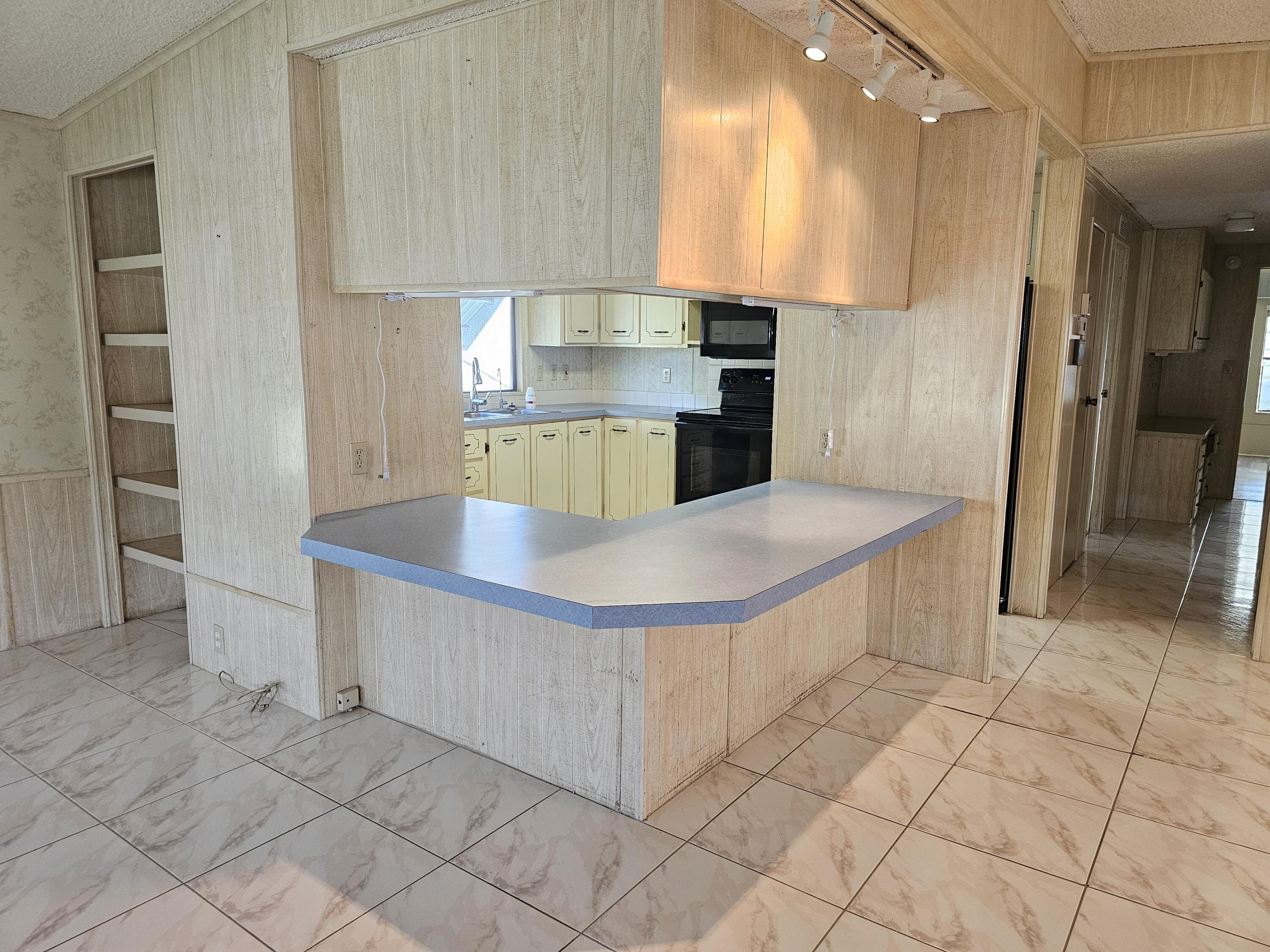 6978 Southeast Delegate Street Hobe Sound, FL 33455 - Photo 8 of 24 a kitchen with stainless steel appliances a sink and a refrigerator