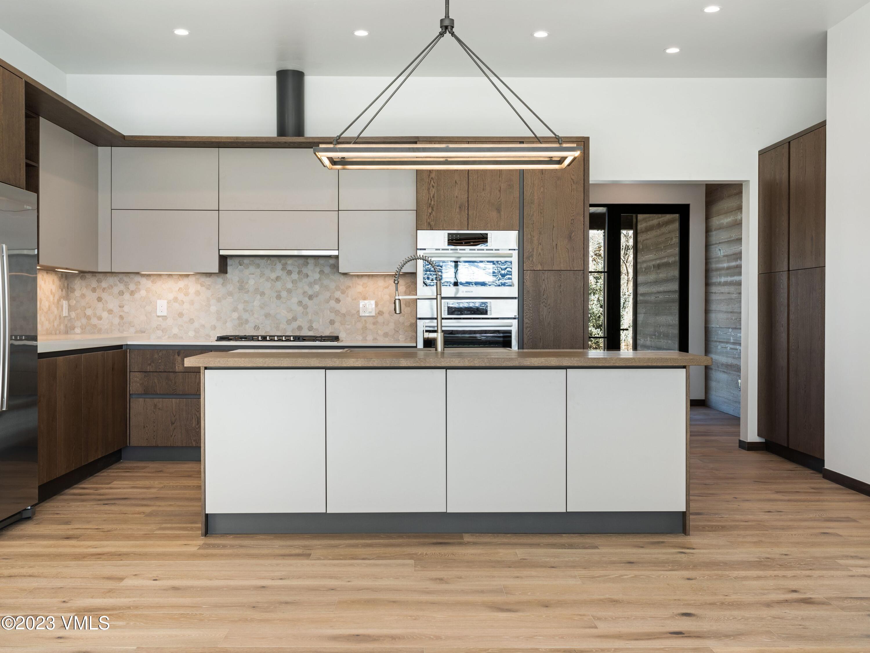 2494 Eagle Ranch Road Eagle, CO 81631 - Photo 15 of 49 a kitchen with kitchen island granite countertop a sink cabinets and wooden floor