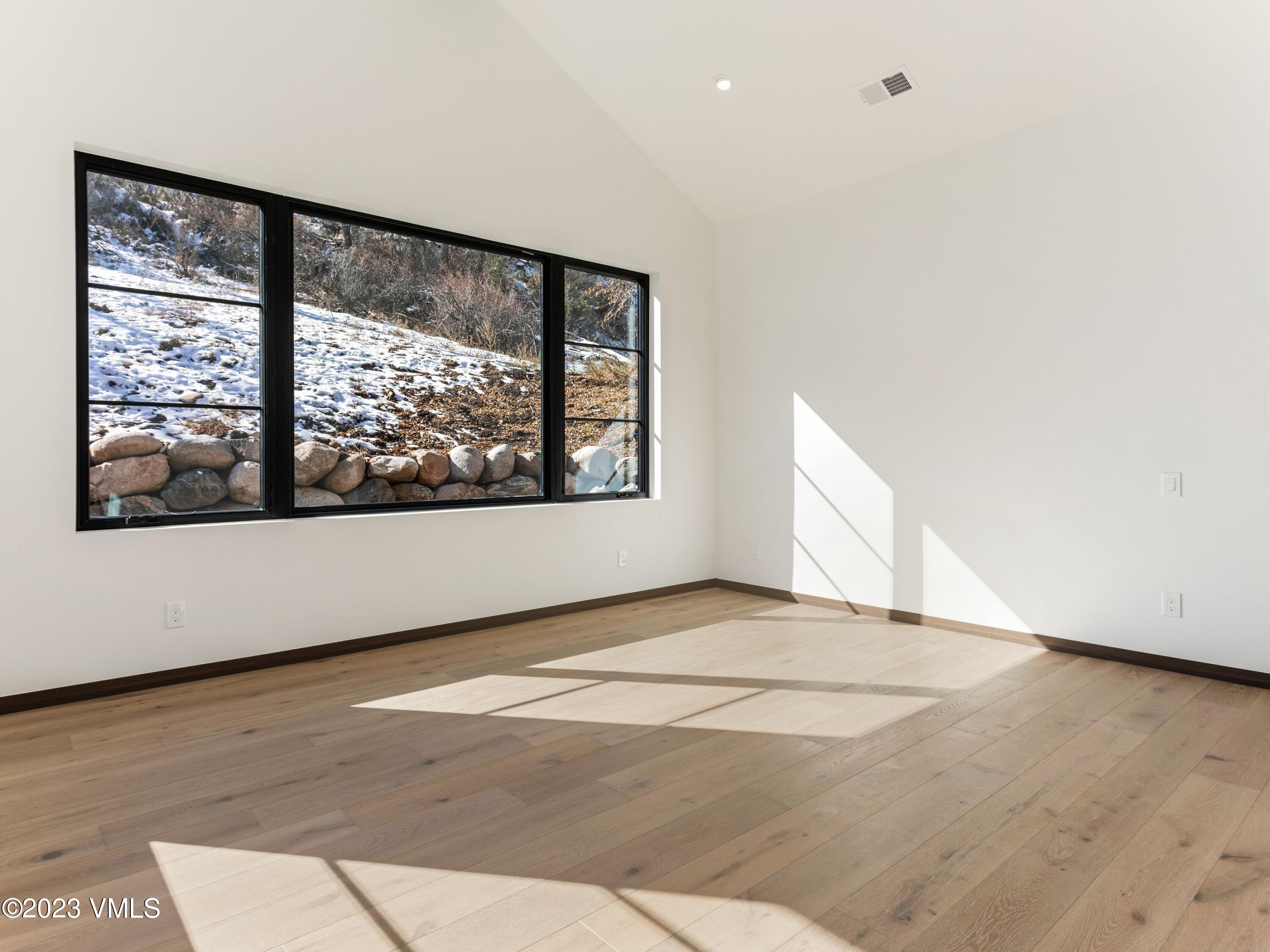 2494 Eagle Ranch Road Eagle, CO 81631 - Photo 19 of 49 a view of an empty room with wooden floor and a window