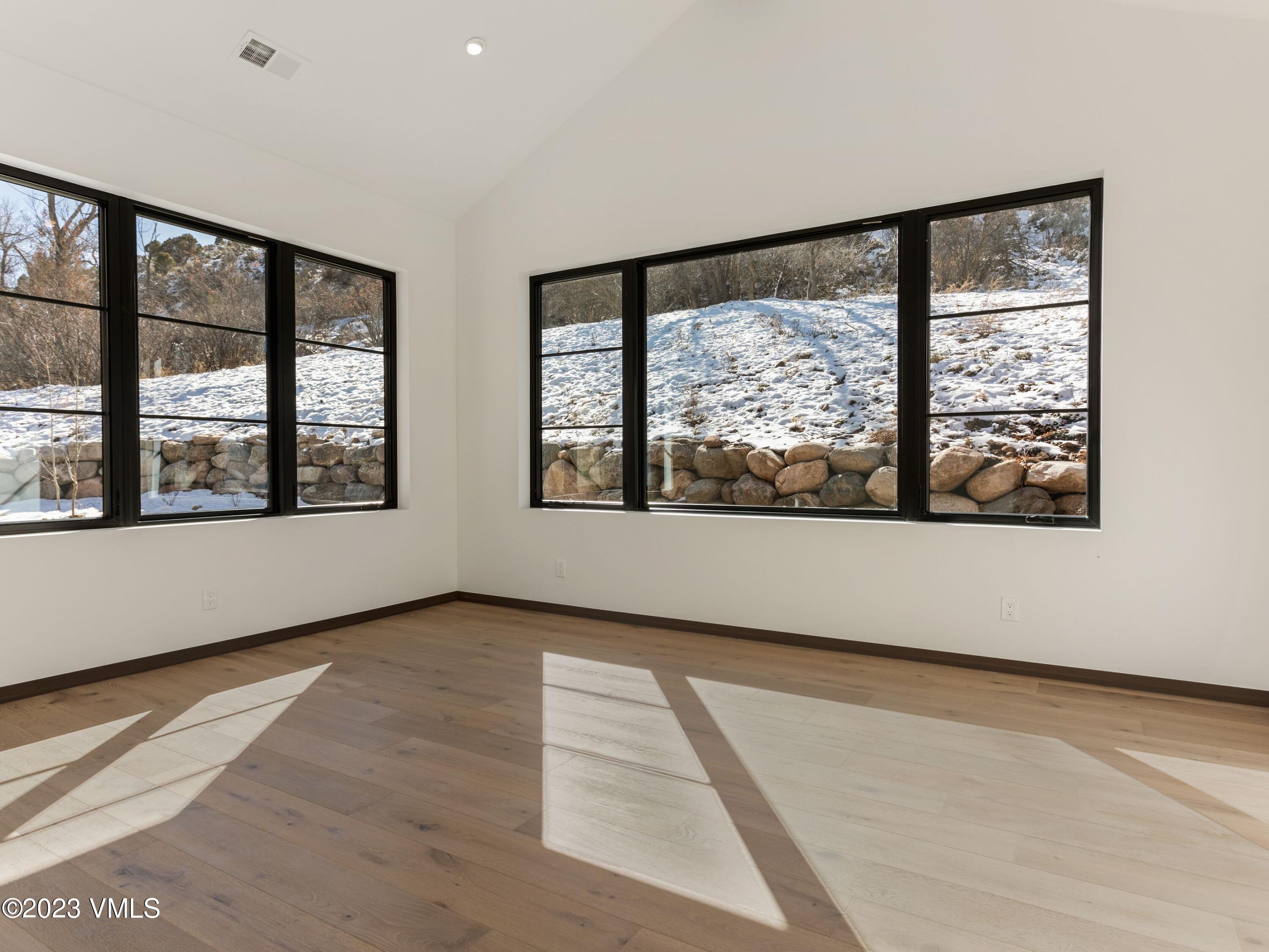 2494 Eagle Ranch Road Eagle, CO 81631 - Photo 21 of 49 a view of an empty room with wooden floor and a window