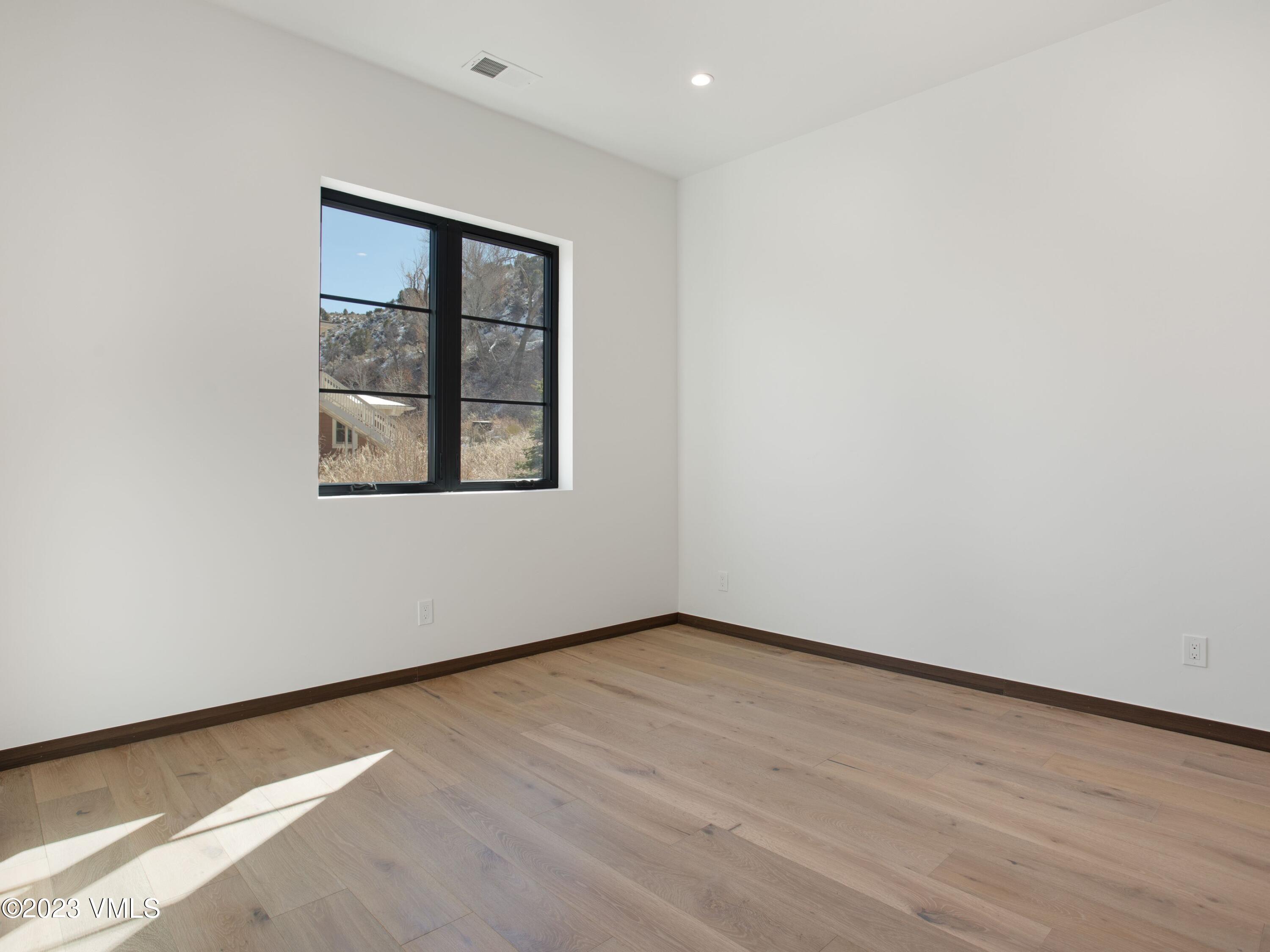 2494 Eagle Ranch Road Eagle, CO 81631 - Photo 32 of 49 an empty room with wooden floor and a window