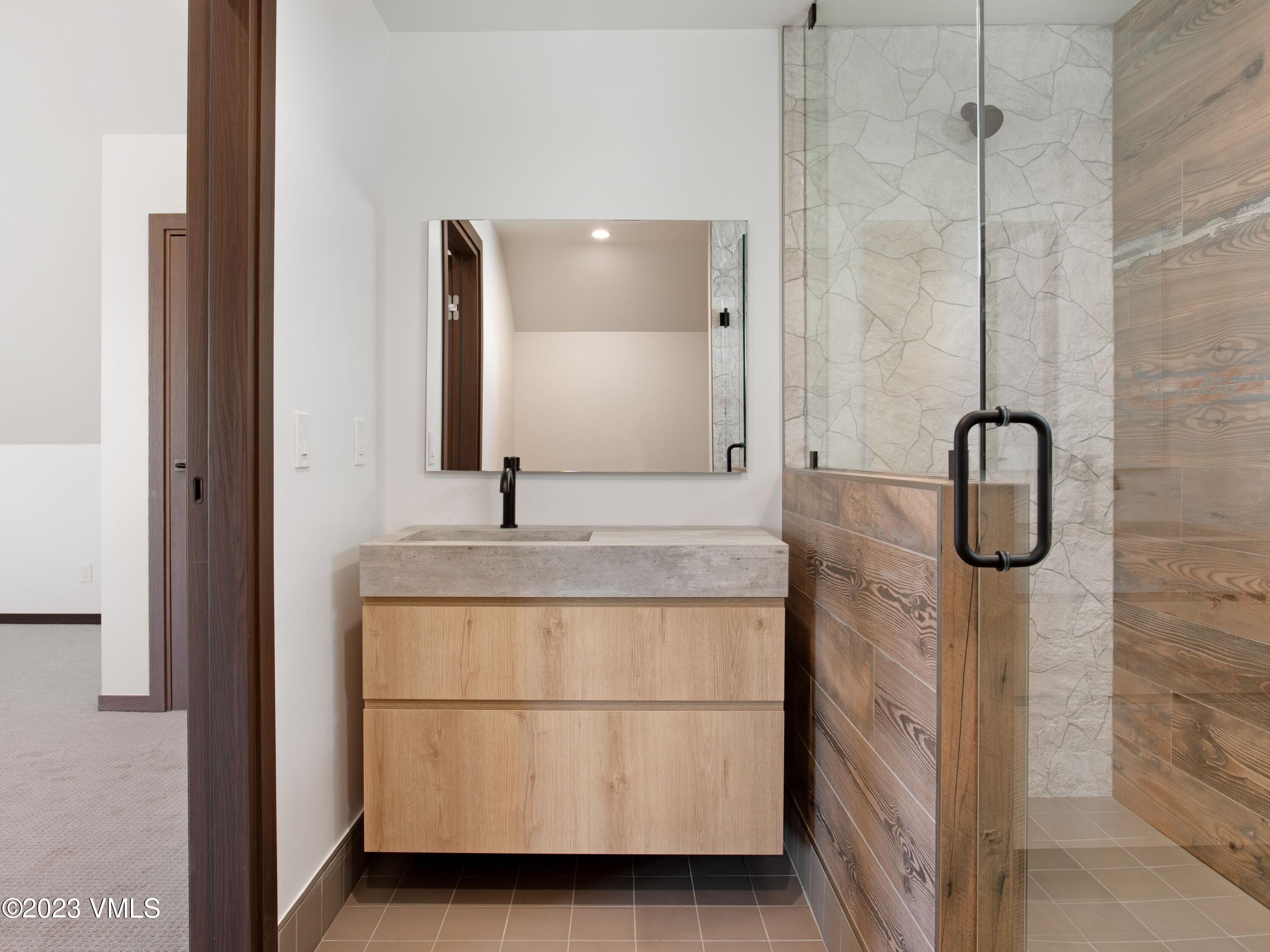 2494 Eagle Ranch Road Eagle, CO 81631 - Photo 36 of 49 a bathroom with a granite countertop sink a mirror and shower