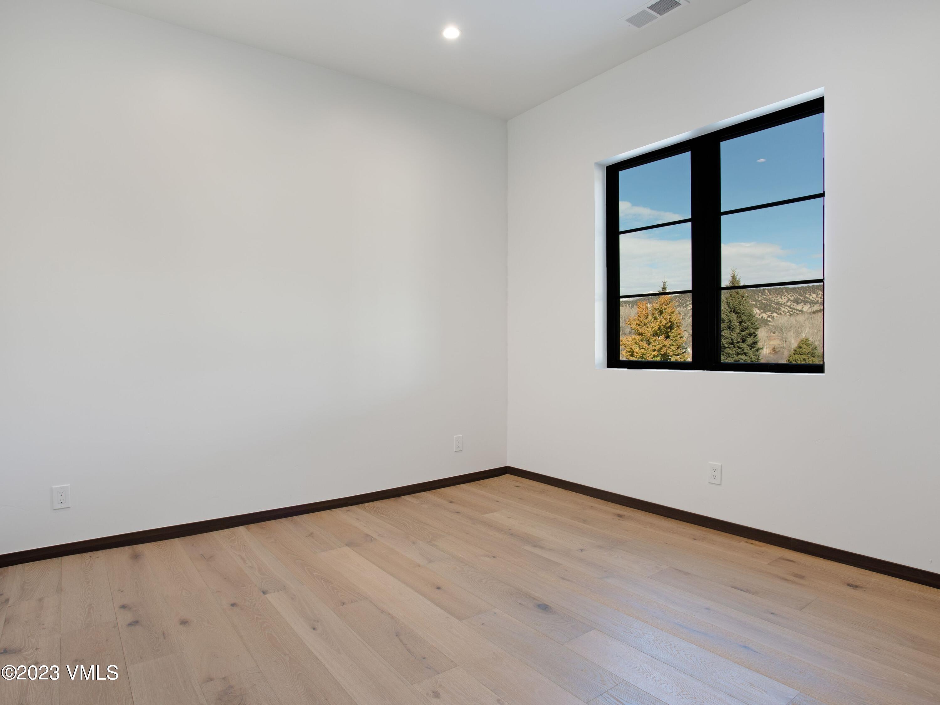 2494 Eagle Ranch Road Eagle, CO 81631 - Photo 37 of 49 a view of an empty room with wooden floor and a window