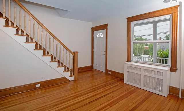a view of an entryway with wooden floor and door