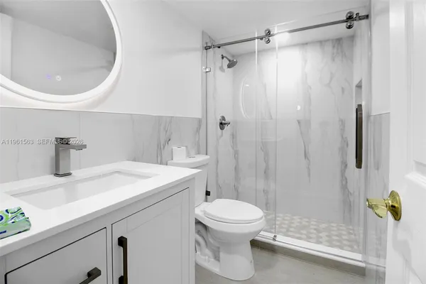 a bathroom with a sink a toilet and shower