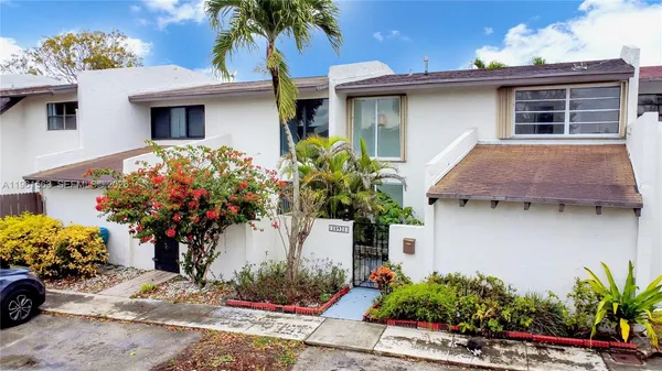 a front view of a house with a yard and a garden
