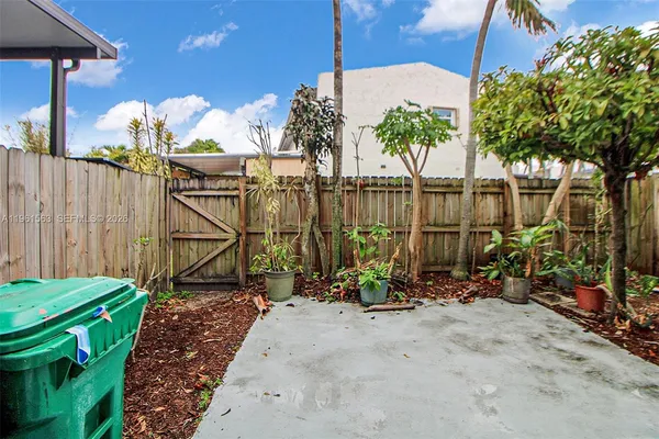 a front view of a house with a yard and potted plants