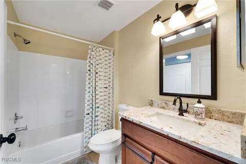 a bathroom with a granite countertop sink toilet and shower