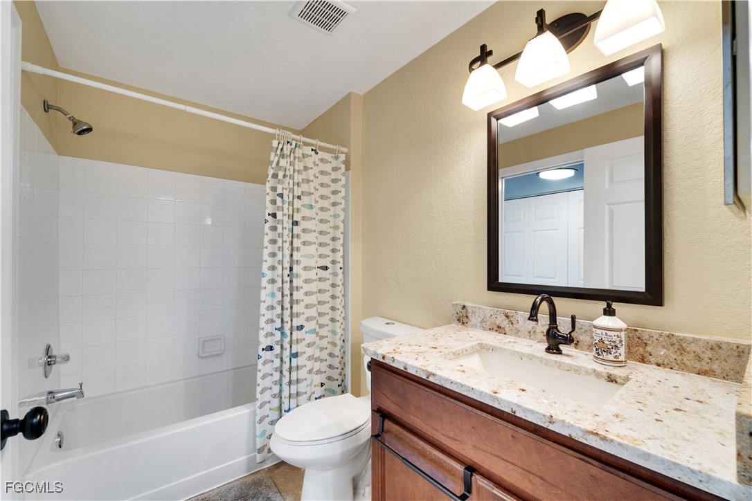 6450 Aragon Way, Unit 202 Fort Myers, FL 33966 - Photo 11 of 24 a bathroom with a granite countertop sink toilet and shower
