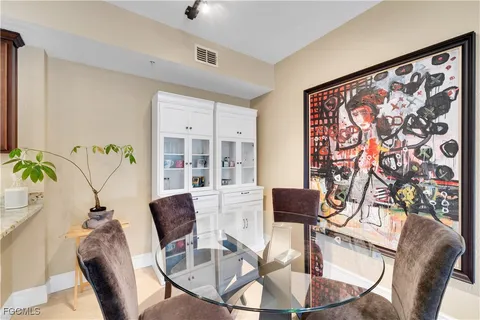 a view of a dining room with furniture a potted plant and wooden floor