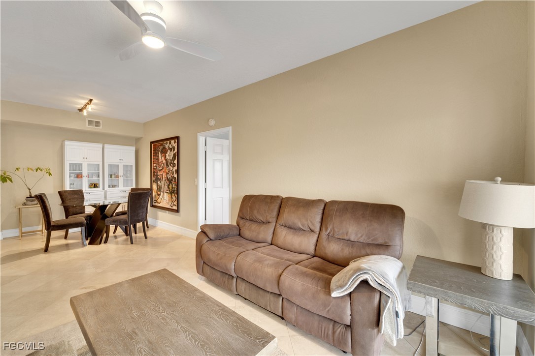 6450 Aragon Way, Unit 202 Fort Myers, FL 33966 - Photo 19 of 24 a living room with furniture a lamp on table and a window