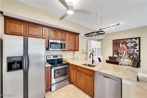 a kitchen with stainless steel appliances granite countertop a refrigerator a stove and a sink