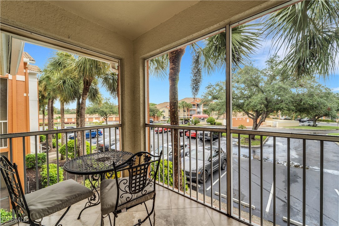6450 Aragon Way, Unit 202 Fort Myers, FL 33966 - Photo 10 of 24 a view of a balcony with chairs and wooden floor