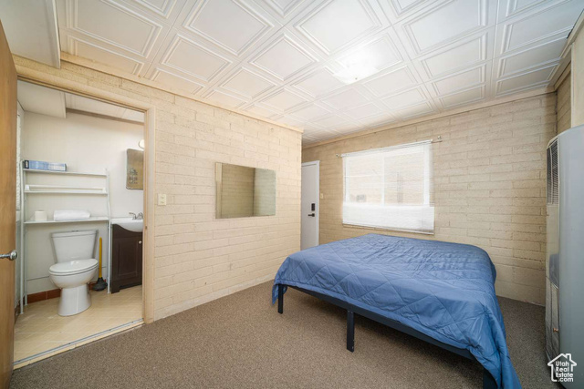 52 South Main Street Paris, ID 83261 - Photo 19 of 27 Carpeted bedroom featuring brick wall, a heating unit, ensuite bathroom, and an ornate ceiling