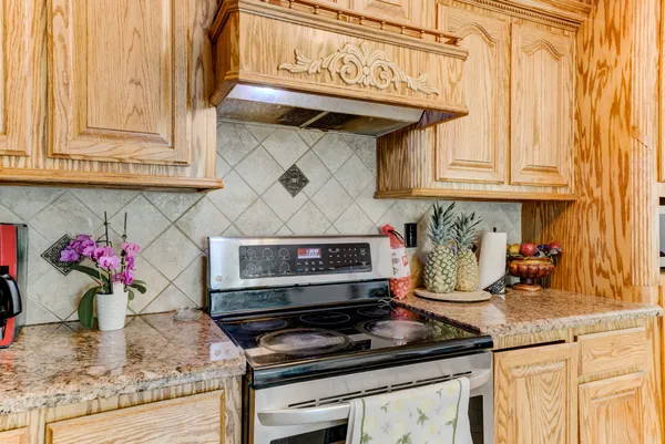 a kitchen with granite countertop a stove and cabinets
