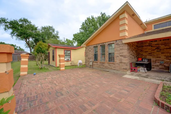 a view of a house with backyard and a tree