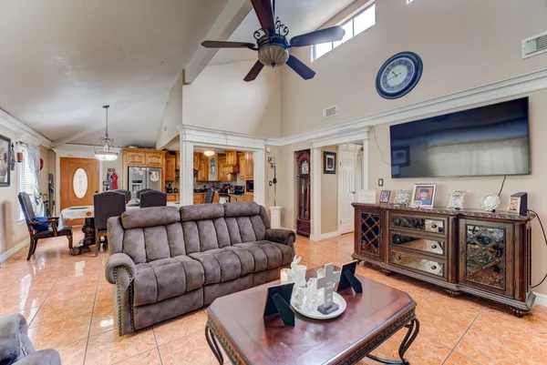 a living room with furniture a flat screen tv and kitchen view