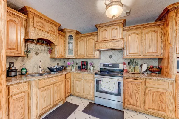 a kitchen with stainless steel appliances granite countertop a stove a sink and cabinets