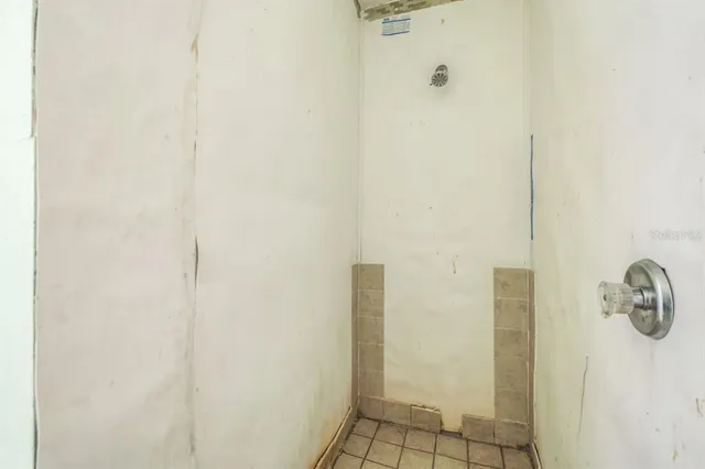 a bedroom with filled bed and a window