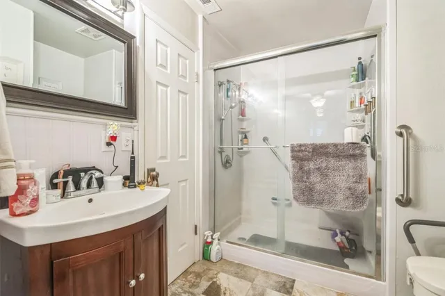 a bathroom with a granite countertop toilet and a sink