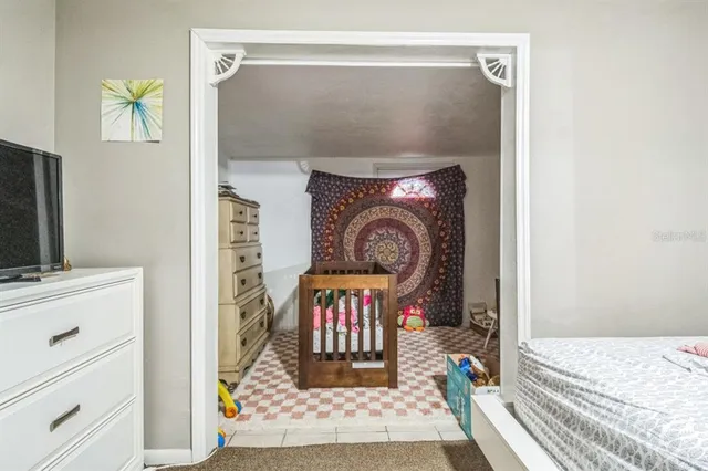 a backyard of a house with wooden fence and a large tree
