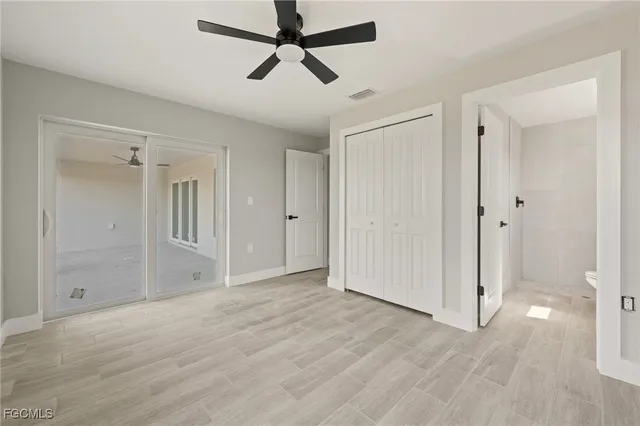 a view of empty room with wooden floor and ceiling fan