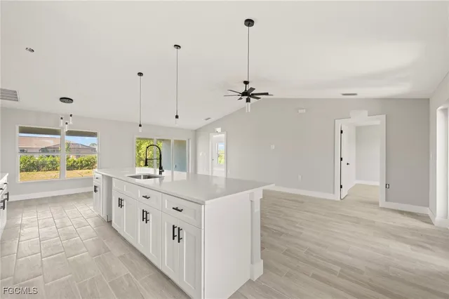 a kitchen with stainless steel appliances sink cabinets and wooden floor