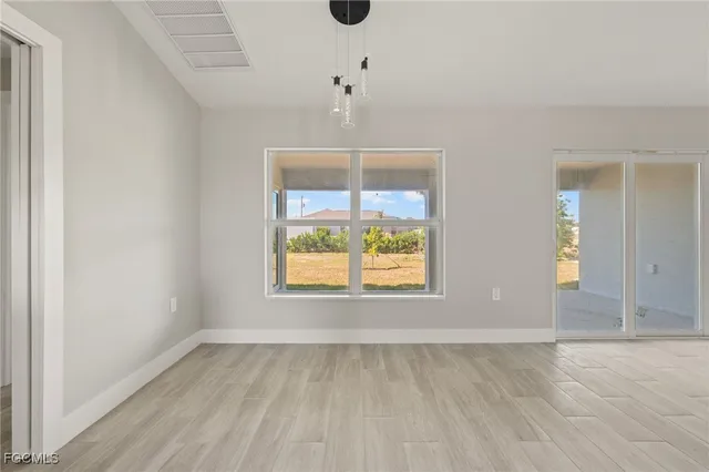 an empty room with a window and wooden floor