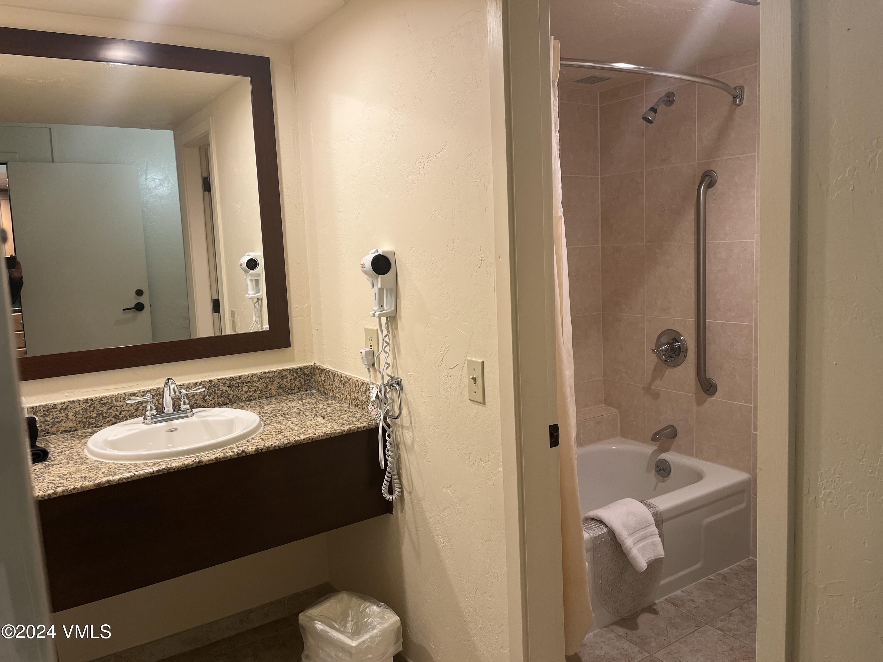 1020 Vail View Drive, Unit 340325 Vail, CO 81657 - Photo 6 of 25 a bathroom with a granite countertop sink tub and mirror