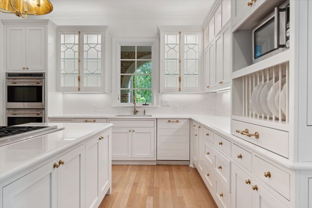 a kitchen with granite countertop white cabinets and white appliances