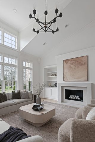 a living room with furniture a fireplace and a chandelier