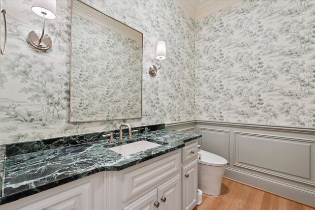 a bathroom with a granite countertop sink a toilet and a mirror