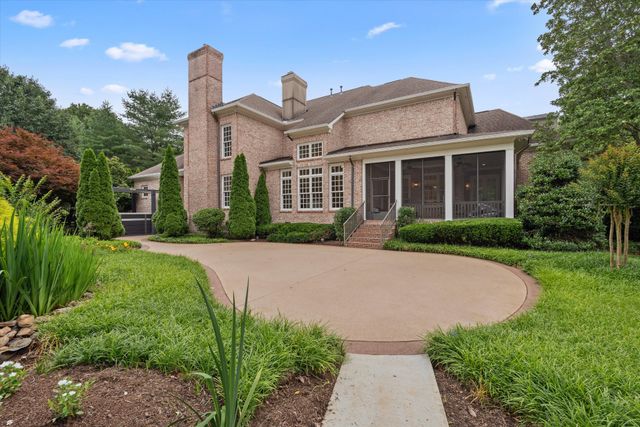 an aerial view of residential house with outdoor space and trees all around