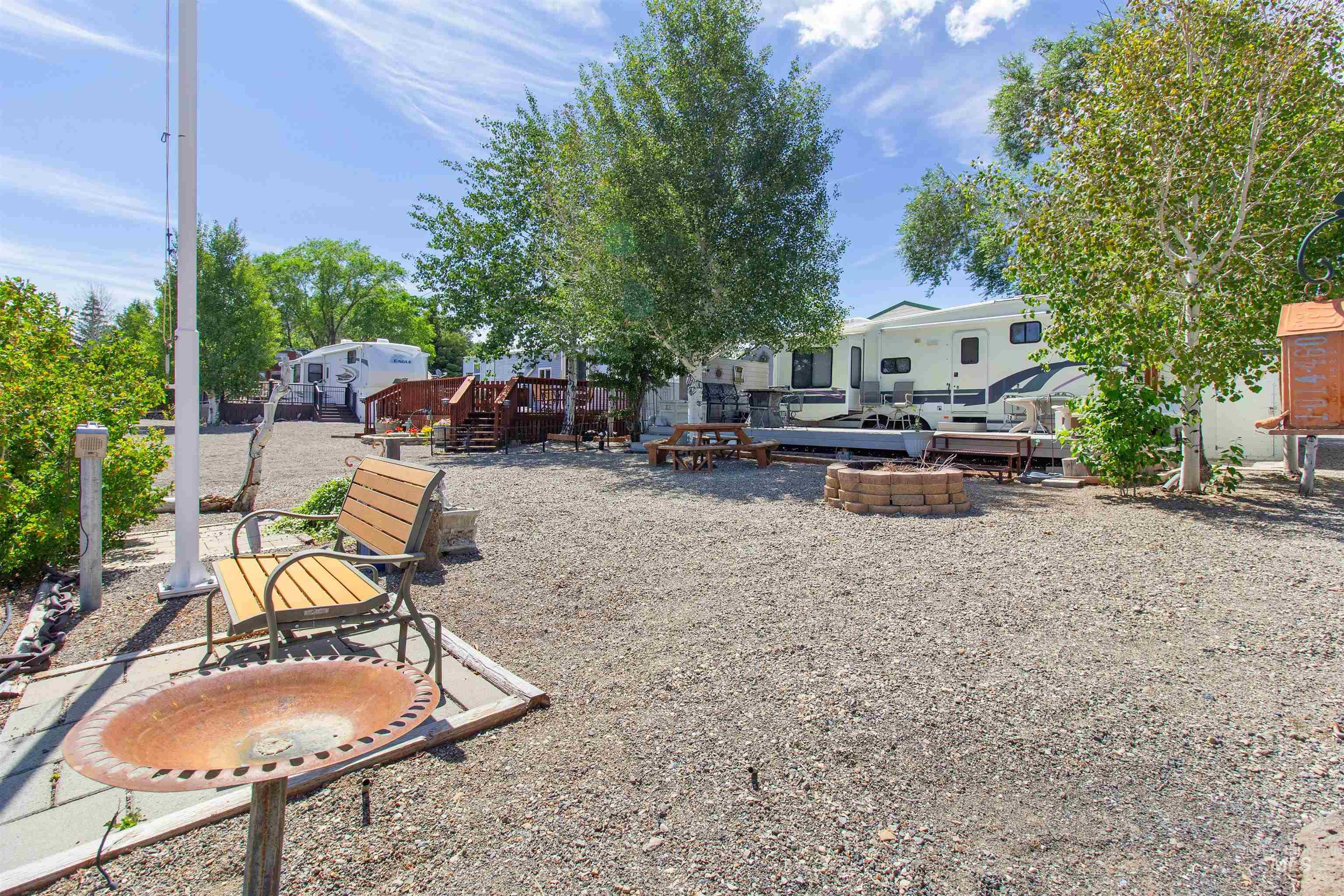 106 West Magic Road Shoshone, ID 83352 - Photo 35 of 45 Gravel lot featuring a stone fire pit, wood picnic tables, and mature trees