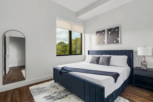 a view of a hallway with wooden floor and a cabinet