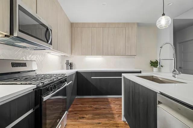 a kitchen with granite countertop a refrigerator and a stove top oven