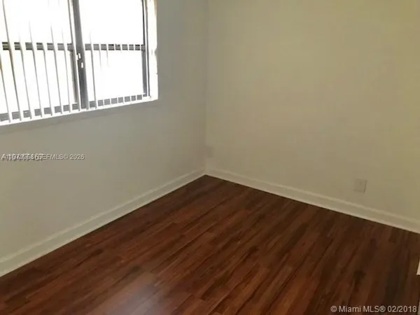 a view of a small space with wooden floor and a window